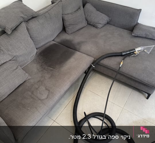 ספה אפורה עם כתמים וצינור ניקוי